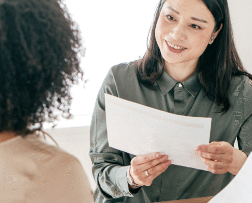 Two women discussing hiring metrics in an office setting.
