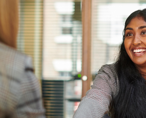 A woman in an interview answering "What are you looking for a new position?"